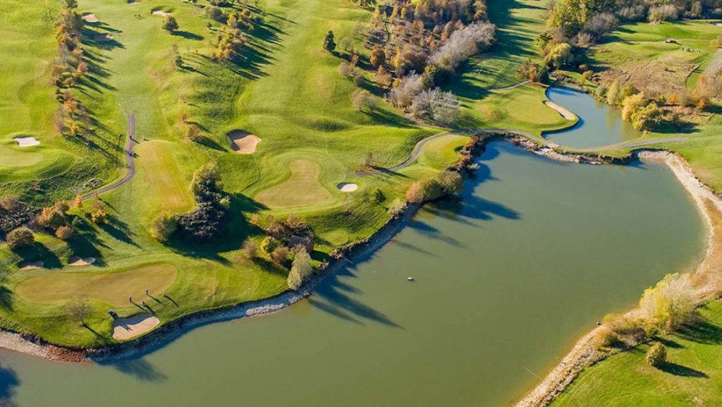 birds eye view over golf club with lake in foreground