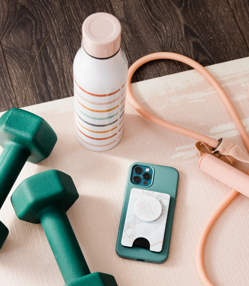 Weights, phone, skipping rope and water bottle on exercise mat