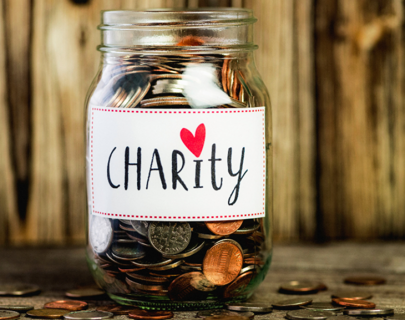 Jar with coins with the word charity written on