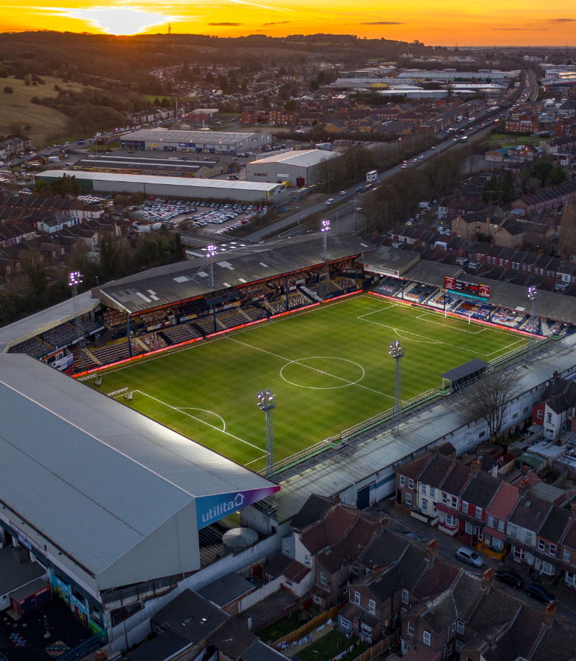 English football ground in evening sunlight